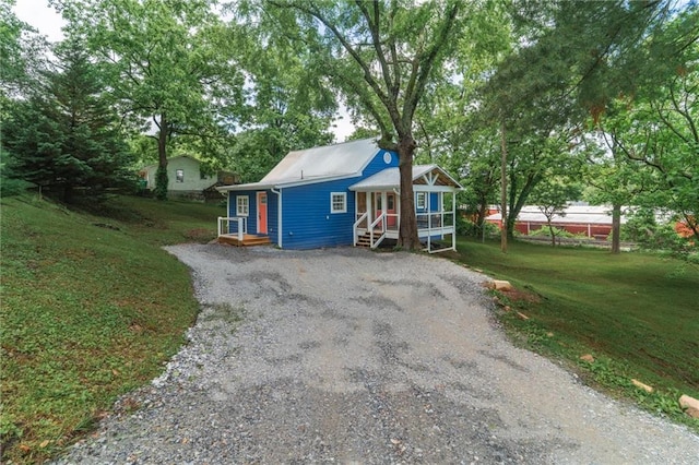 235 Lowry St, Ball Ground, GA 30107 - view of front of home with gravel driveway and a front yard
