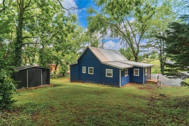 235 Lowry St, Ball Ground, GA 30107 - view of side of property featuring a lawn, a storage unit, and an outbuilding