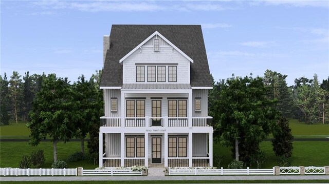 view of front of home featuring a front lawn, fence, and a balcony