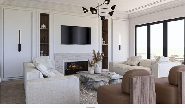 living room with crown molding, built in features, a glass covered fireplace, and wood finished floors