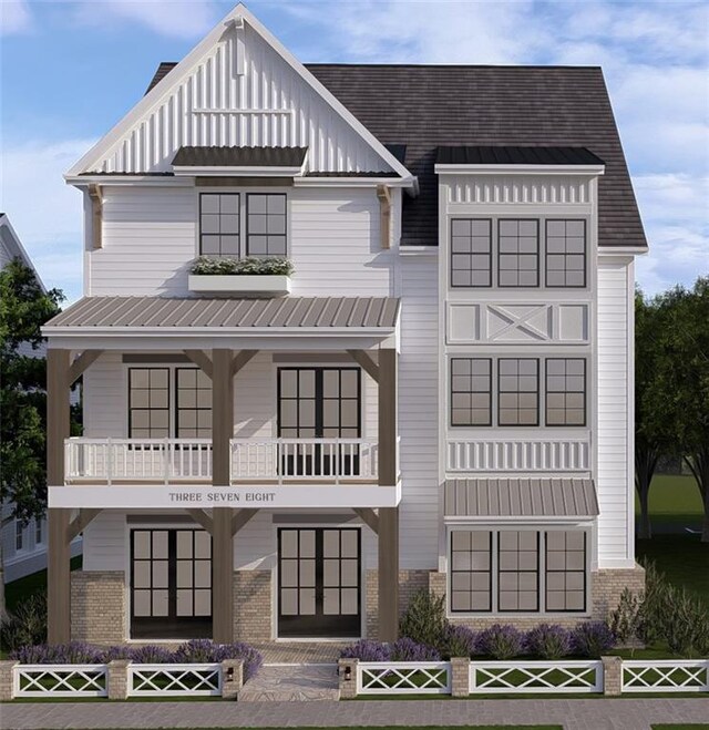 view of front facade with board and batten siding, brick siding, a standing seam roof, and metal roof