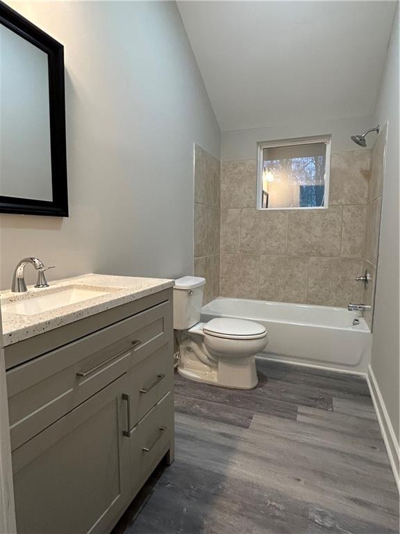 10033 Florence Cir, Villa Rica, GA 30180 - full bathroom with toilet, tiled shower / bath combo, hardwood / wood-style flooring, lofted ceiling, and vanity