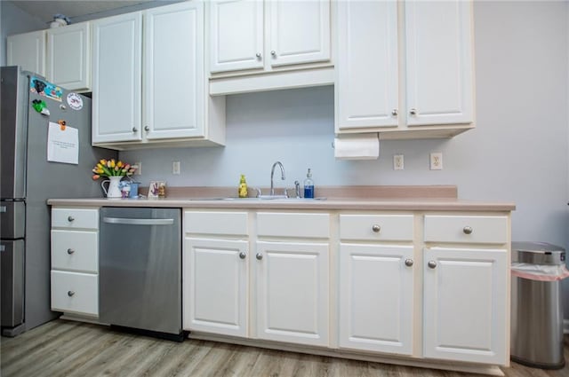 kitchen featuring sink, light hardwood / wood-style flooring, stainless steel appliances, and white cabinets