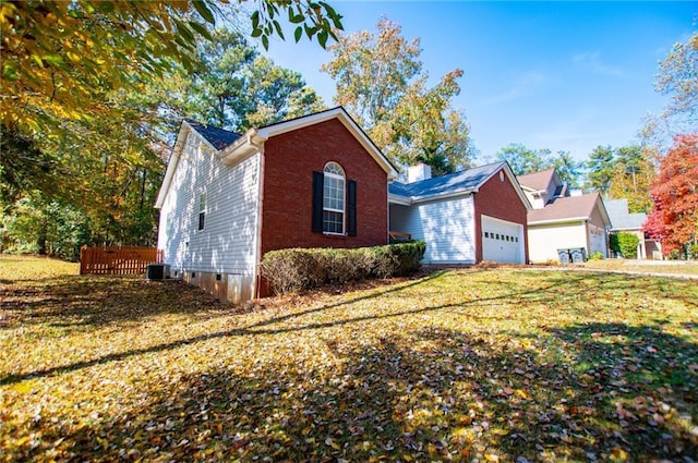 view of front of home featuring cooling unit, a garage, and a front yard