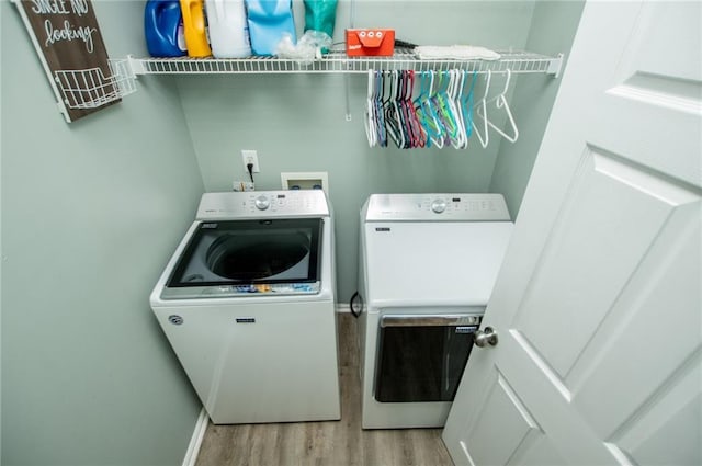 laundry area with light hardwood / wood-style flooring and independent washer and dryer