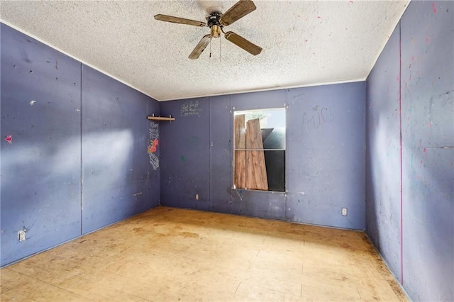 unfurnished room featuring ceiling fan and a textured ceiling