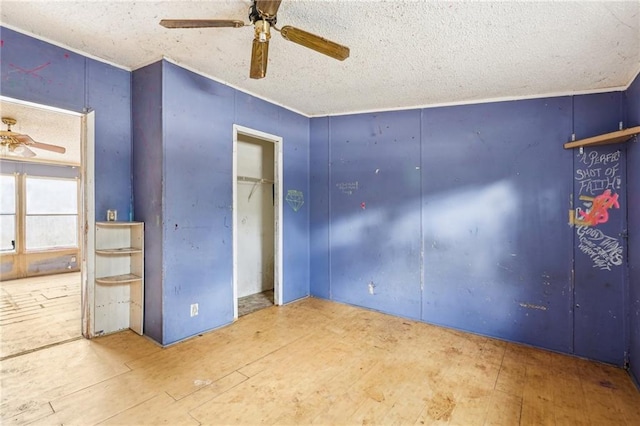 unfurnished bedroom with ceiling fan, wood-type flooring, and a textured ceiling