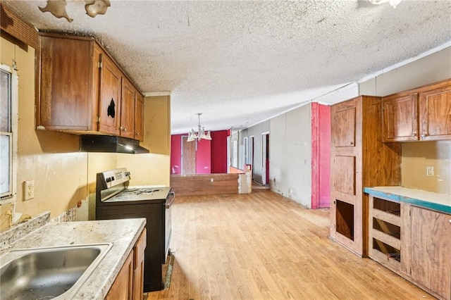 kitchen featuring a textured ceiling, hanging light fixtures, light hardwood / wood-style flooring, a notable chandelier, and electric stove