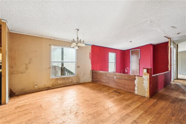 interior space with hardwood / wood-style floors, a textured ceiling, and an inviting chandelier