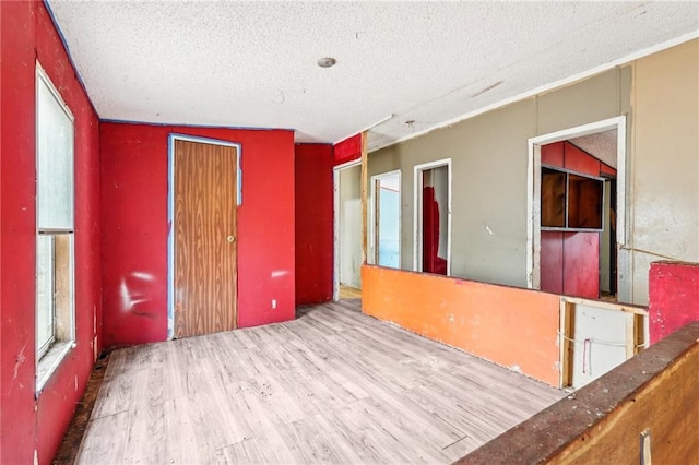 spare room featuring wood-type flooring and a textured ceiling