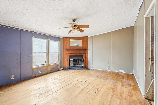 unfurnished living room featuring ceiling fan, a textured ceiling, and light hardwood / wood-style floors