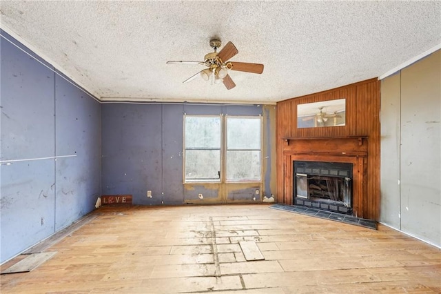 unfurnished living room featuring ceiling fan, a textured ceiling, and light hardwood / wood-style floors