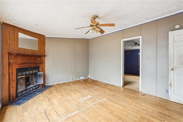 unfurnished living room with hardwood / wood-style flooring, ceiling fan, and a textured ceiling