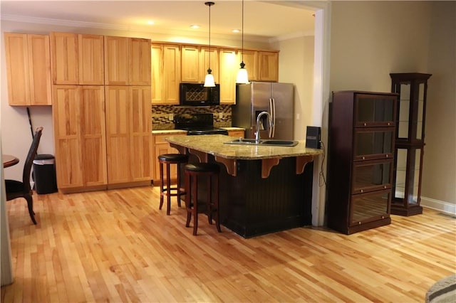 kitchen with backsplash, decorative light fixtures, crown molding, black appliances, and light stone countertops