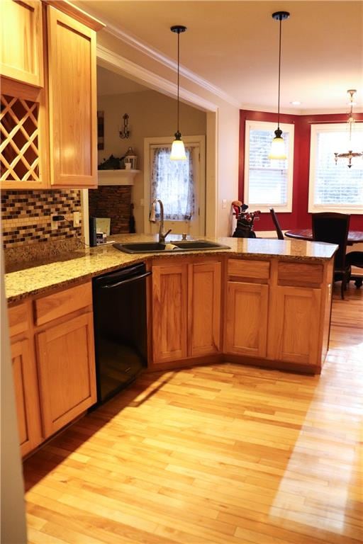 kitchen featuring sink, black dishwasher, pendant lighting, and kitchen peninsula