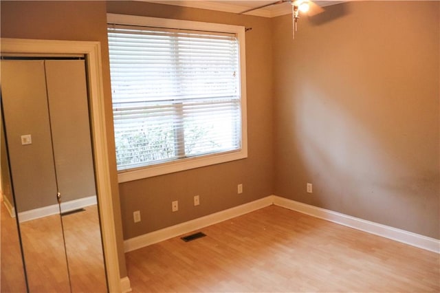 unfurnished bedroom with hardwood / wood-style floors, a closet, and ceiling fan