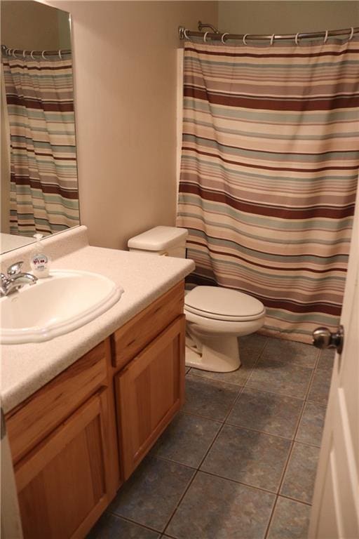 bathroom with toilet, vanity, tile patterned flooring, and a shower with shower curtain