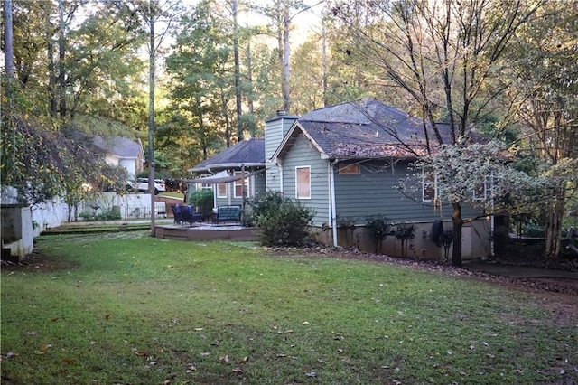 view of side of property featuring a deck and a lawn