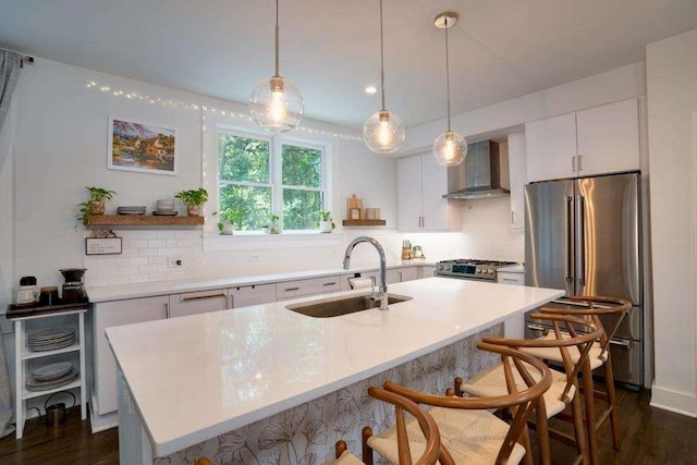 kitchen with white cabinetry, sink, wall chimney exhaust hood, hanging light fixtures, and stainless steel appliances