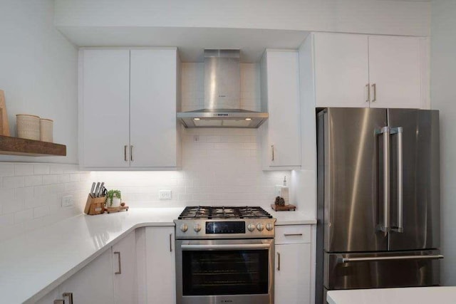 kitchen with tasteful backsplash, white cabinetry, wall chimney exhaust hood, and premium appliances