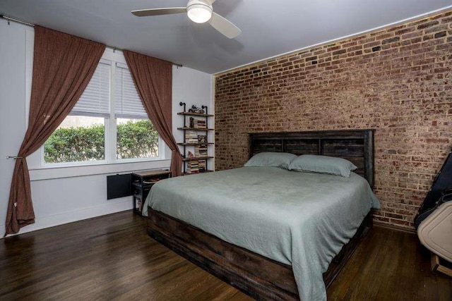 bedroom featuring ceiling fan, dark hardwood / wood-style flooring, and brick wall