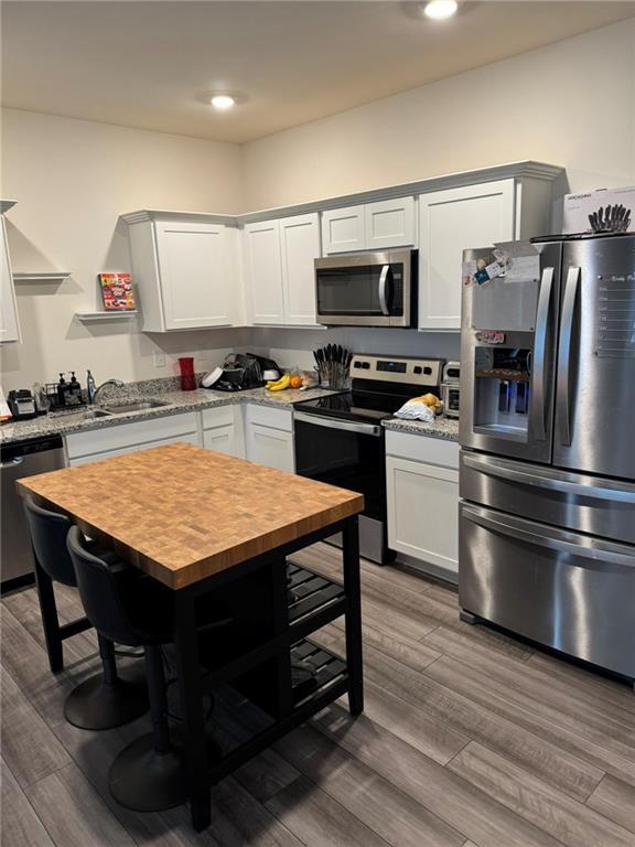 536 Magnolia Cir Unit 116, Palmetto, GA 30268 - kitchen with stainless steel appliances, wood counters, a sink, wood finished floors, and recessed lighting