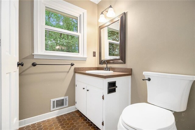bathroom featuring vanity, toilet, and baseboards