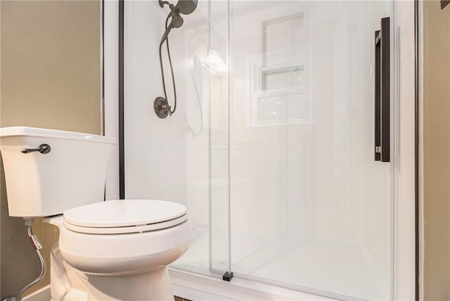 full bathroom with a stall shower and toilet