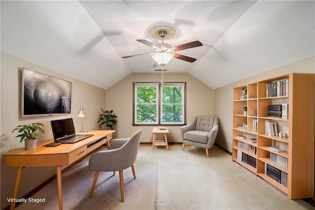 office area with a ceiling fan, vaulted ceiling, baseboards, and light colored carpet