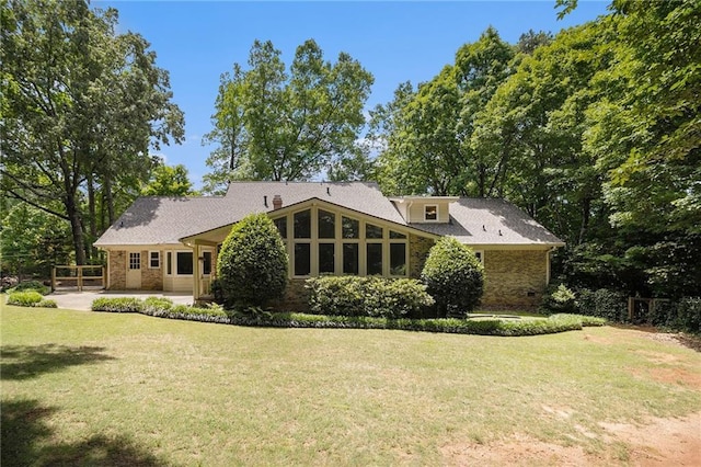 back of house with a yard, a patio area, and brick siding