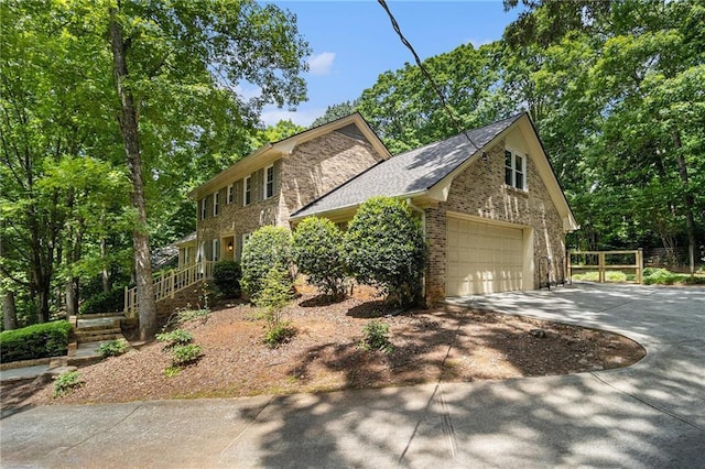 view of side of property featuring concrete driveway, brick siding, and stone siding