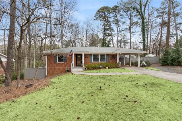 ranch-style home with brick siding, concrete driveway, fence, a carport, and a front yard