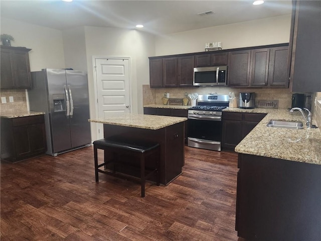 556 Emporia Loop, Mcdonough, GA 30253 - kitchen featuring stainless steel appliances, a sink, a center island, tasteful backsplash, and light stone counters
