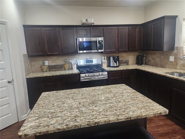 556 Emporia Loop, Mcdonough, GA 30253 - kitchen featuring appliances with stainless steel finishes, light stone countertops, dark brown cabinetry, backsplash, and dark wood-type flooring