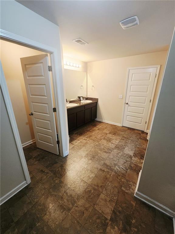 556 Emporia Loop, Mcdonough, GA 30253 - bathroom with vanity, baseboards, and stone finish flooring