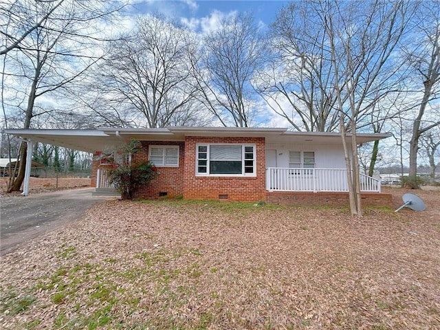 view of front of home with aphalt driveway, an attached carport, crawl space, a porch, and brick siding