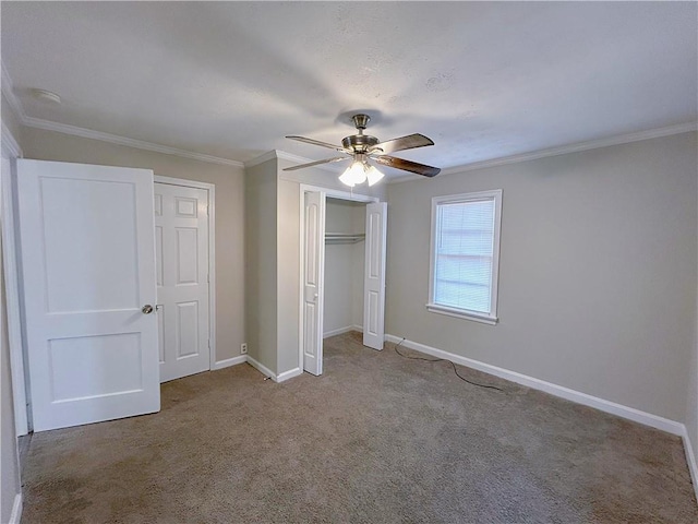 unfurnished bedroom featuring baseboards, a ceiling fan, ornamental molding, carpet floors, and a closet