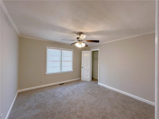 unfurnished bedroom with carpet, a closet, visible vents, ornamental molding, and baseboards