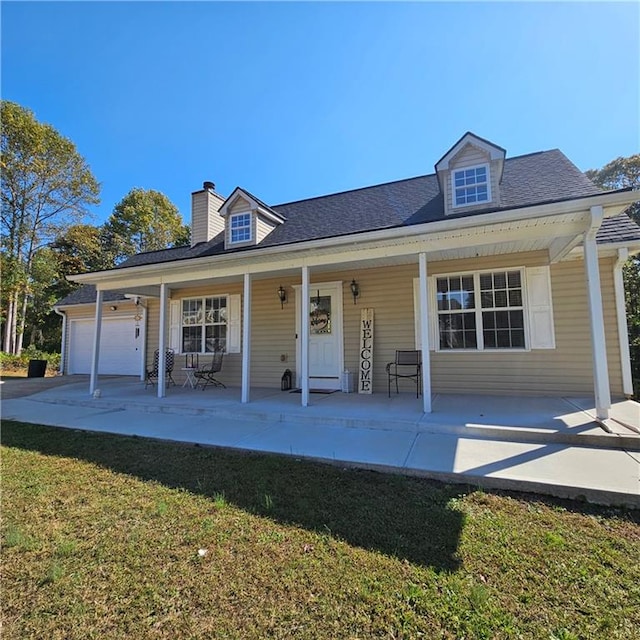 view of front of house with covered porch, a garage, and a front yard