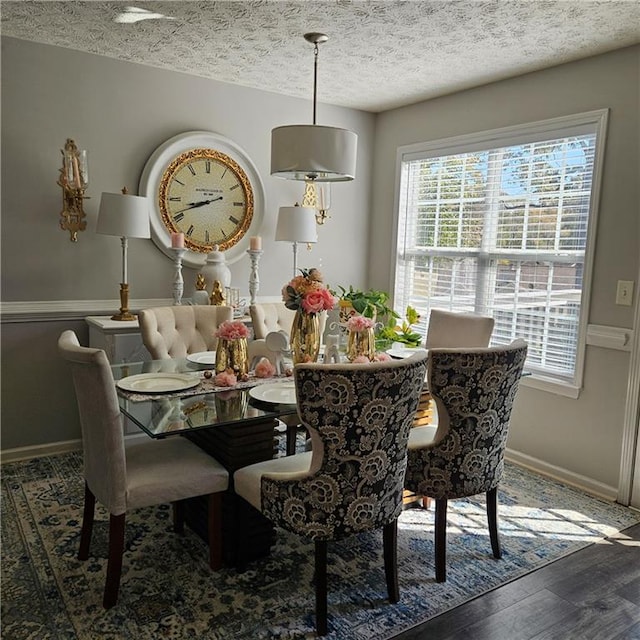 dining area featuring a textured ceiling and dark hardwood / wood-style floors