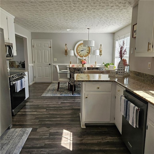 kitchen with kitchen peninsula, light stone counters, white cabinetry, dark wood-type flooring, and stainless steel appliances