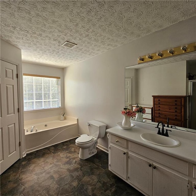 bathroom featuring vanity, a tub, a textured ceiling, and toilet