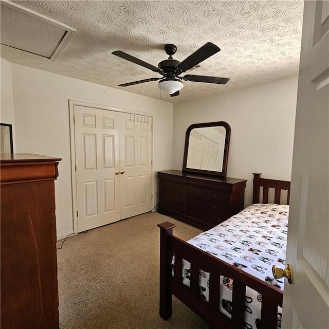 carpeted bedroom with a closet, ceiling fan, and a textured ceiling