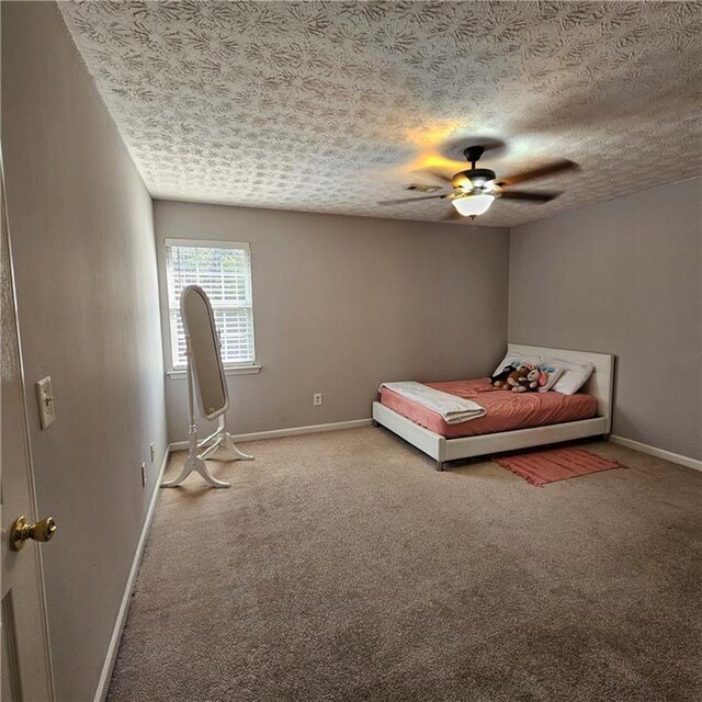 unfurnished bedroom featuring ceiling fan, carpet, and a textured ceiling