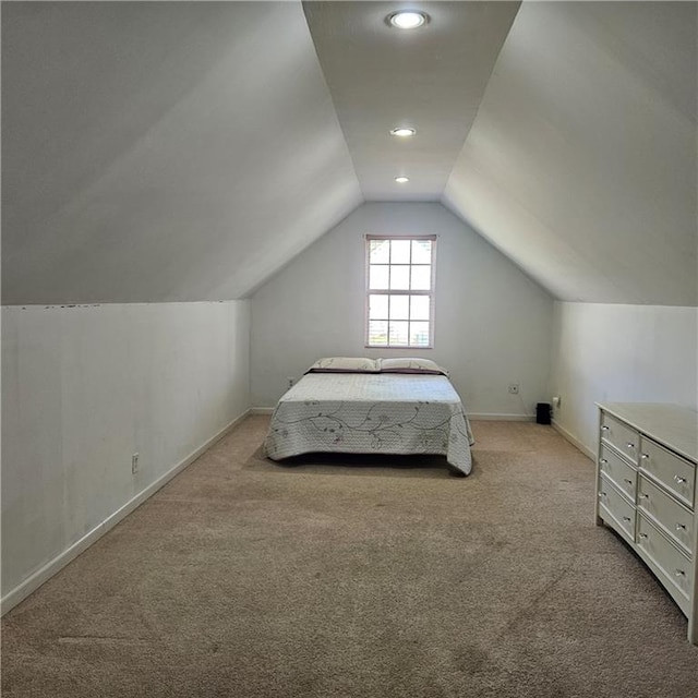 unfurnished bedroom featuring vaulted ceiling and light carpet