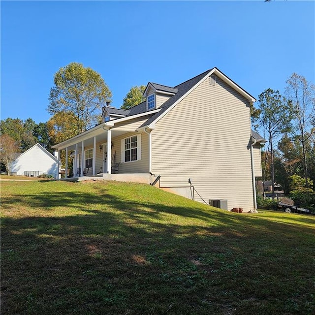 view of side of property featuring a yard and central AC unit