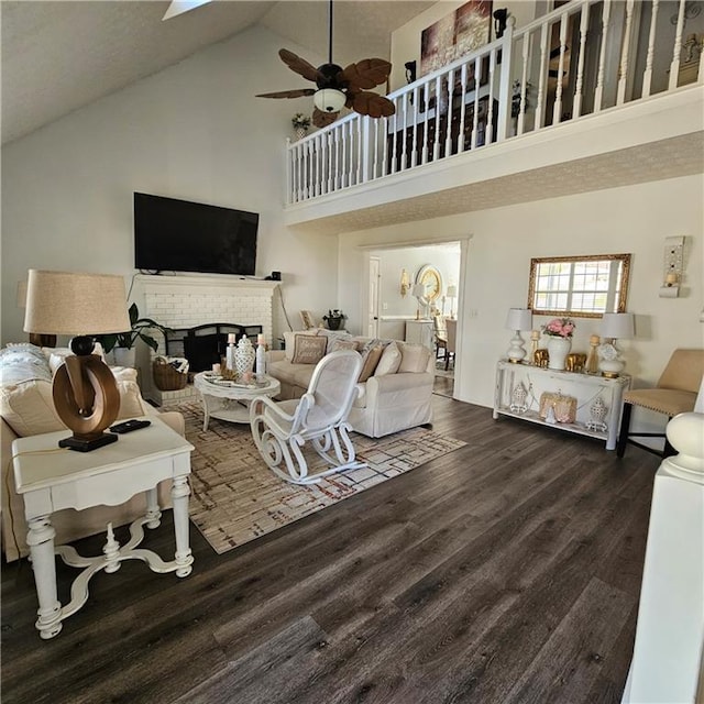 living room featuring dark wood-type flooring, ceiling fan, high vaulted ceiling, and a fireplace