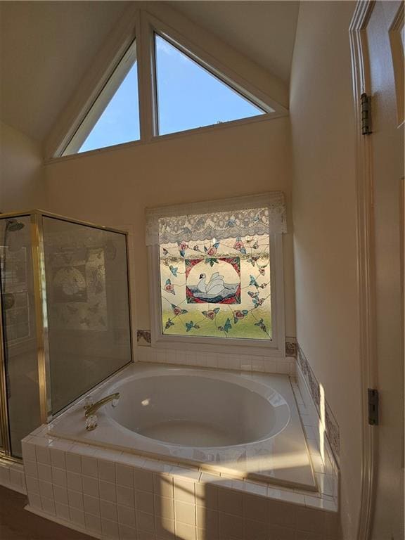bathroom with a bath, plenty of natural light, a stall shower, and lofted ceiling