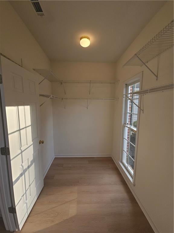 walk in closet with light wood-type flooring and visible vents