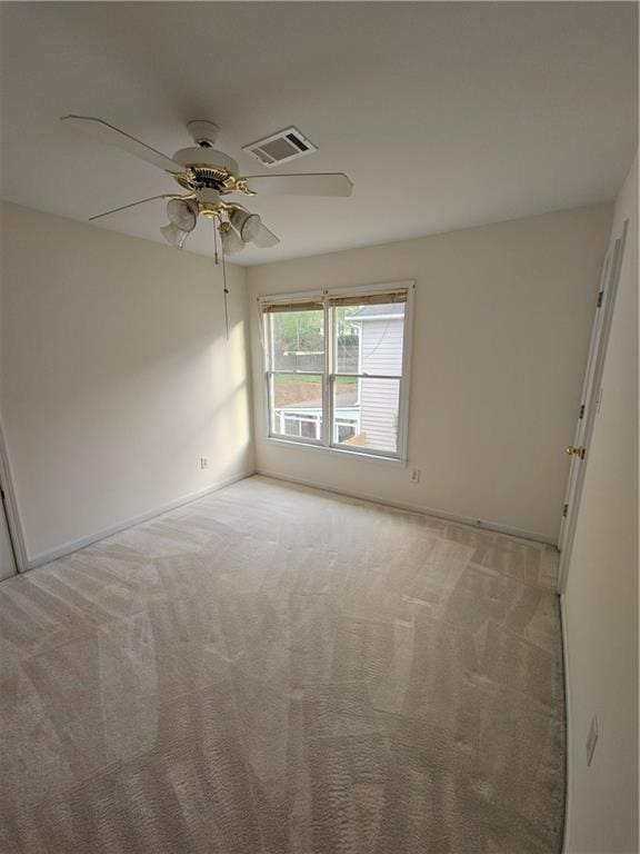 unfurnished room with light carpet, baseboards, a ceiling fan, and visible vents
